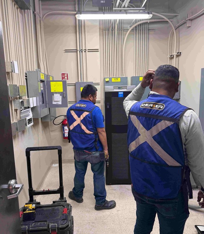 Personal de ENERSER revisando equipo en un cuarto eléctrico